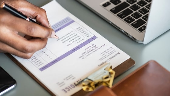 person checking invoice on clipboard