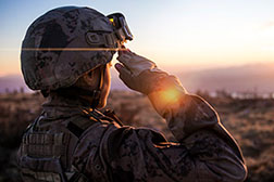 American solider saluting towards the sun.
