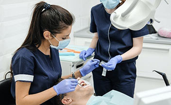 dental assistant helping dentist.