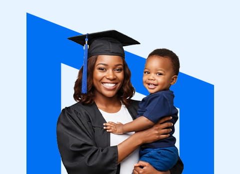 mom in black regalia holding baby in blue shirt and shorts.