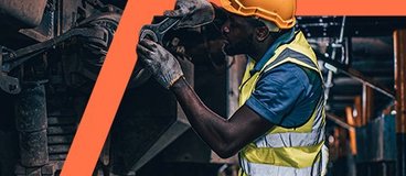 Diesel mechanic in safety gear working on machinery.