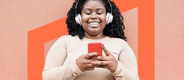 Girl in headphones smiling at smartphone.