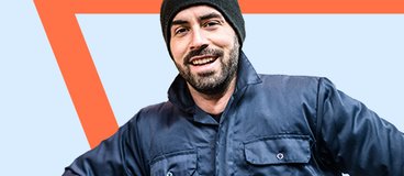 smiling man wearing gloves and a beanie.