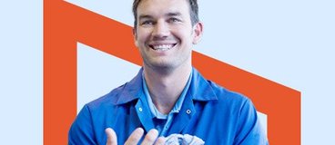 man smiling and wiping his hands on a cloth.