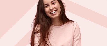 Girl in pink sweater smiling.