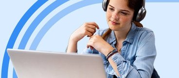 High school student wearing headphones while watching a lesson on their laptop.