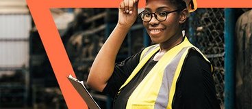 Woman in yellow safety gear holding a clipboard.
