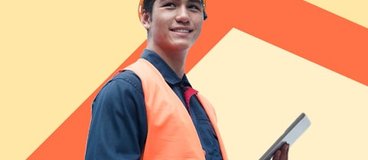 Person in protective gear with tablet on orange background.