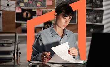 Woman reading through paperwork in office.