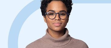 Girl in turtleneck wearing glasses on green and blue background.