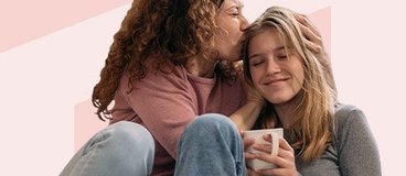 mother kissing her daughter on the head.