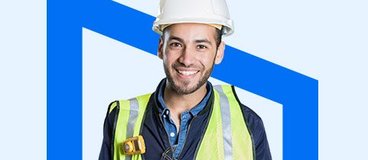 man in hard hat and vest wearing a big smile.