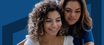 mom and daughter in front of laptop on dark blue background.