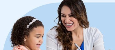 Teacher working with preschool aged girl playing with blocks.