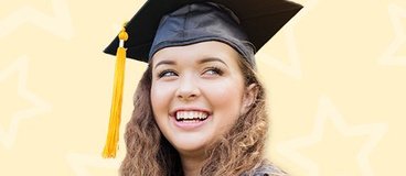 Girl in black cap and gown with yellow tassel smiling on orange background.