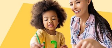 woman and small child playing with an activity table on yellow background.