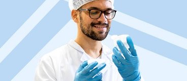 Sterile processing technician in PPE on blue background.