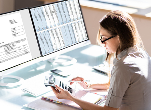 A woman wearing glasses looks at a chart on a piece of paper