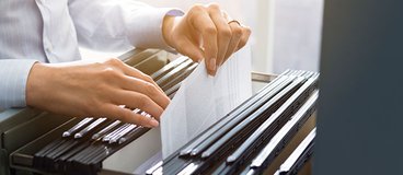 woman looking through a file cabinet.