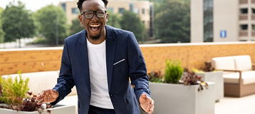 Penn Foster High School graduate, Quintavious Johnson, laughing outside on rooftop deck.