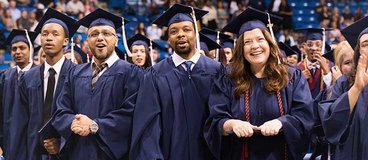 Penn Foster students smiling at a graduation ceremony.
