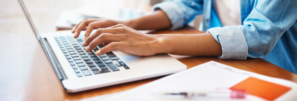 woman typing on laptop.