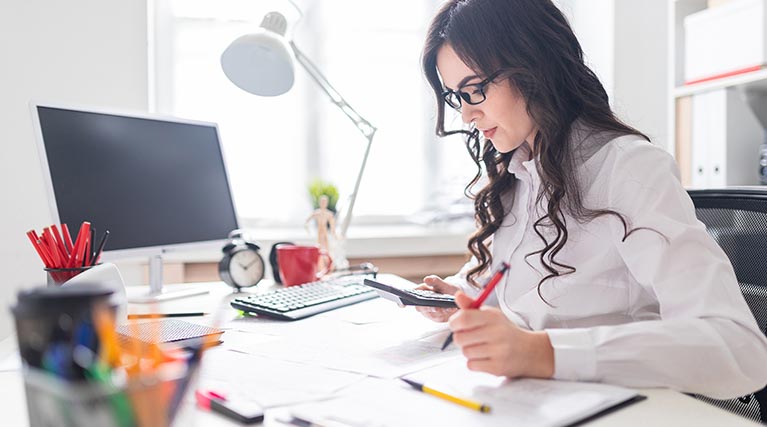 accountant using calculator at desk.