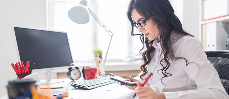 accountant using calculator at desk.