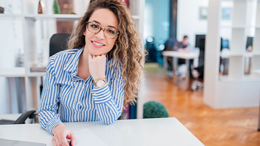 professional woman smiling at desk.
