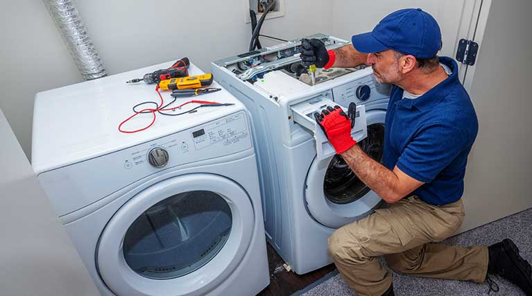 appliance repair technician fixes laundry machine.