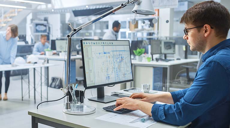 AutoCAD® drafter working on a computer.