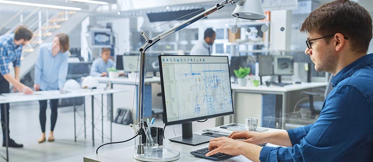 AutoCAD® drafter working on a computer.