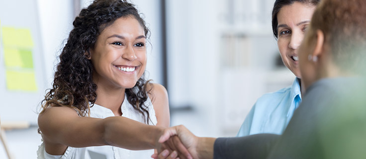 professional woman shaking hands in meeting.