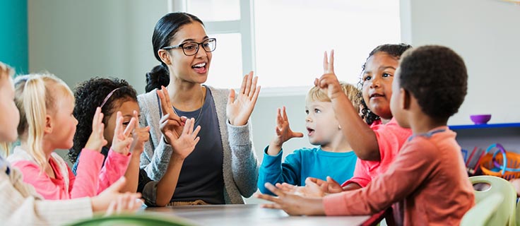 child care professional teaching with students.