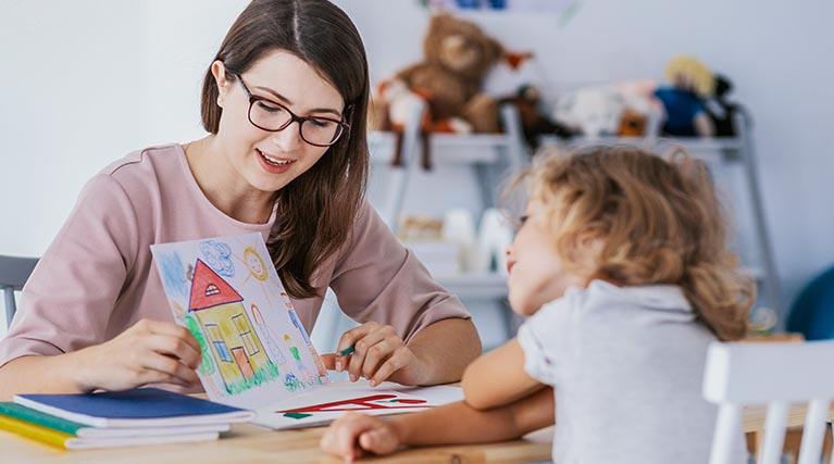 child care professional with student's drawing.