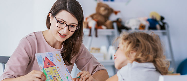 child care professional with student's drawing.