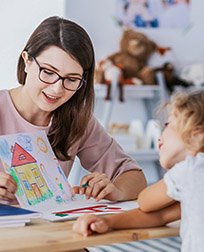 child care professional with student's drawing.