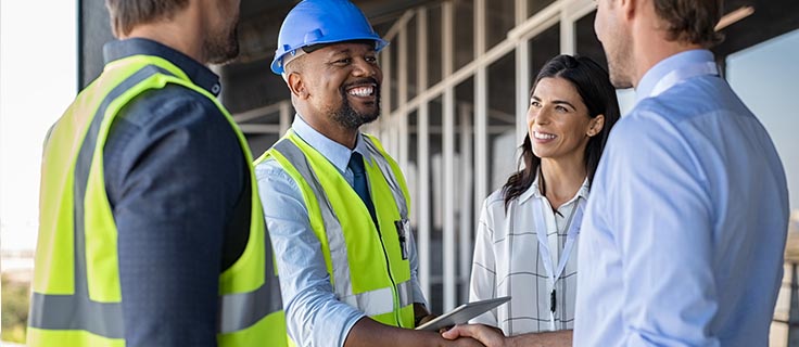 construction manager shaking hands at job site.