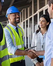 construction manager shaking hands at job site.