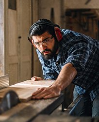man doing woodwork with a saw.