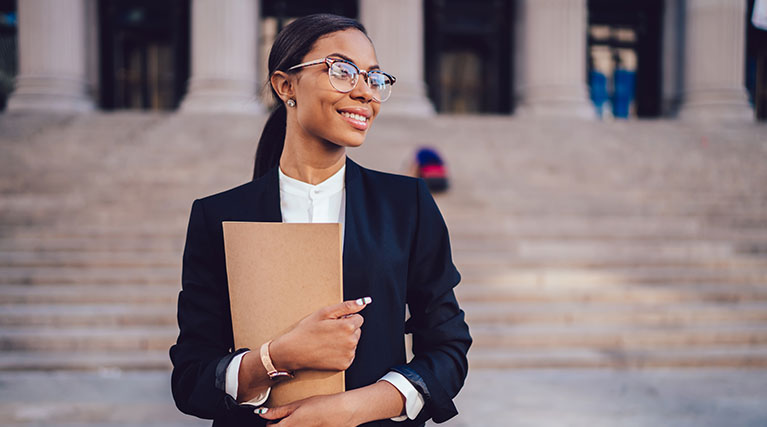 female criminal justice professional in front of courthouse.