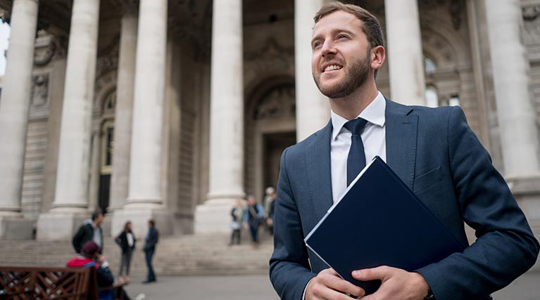 male criminal justice professional in front of courthouse.