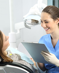 dental assistant talking with patient.
