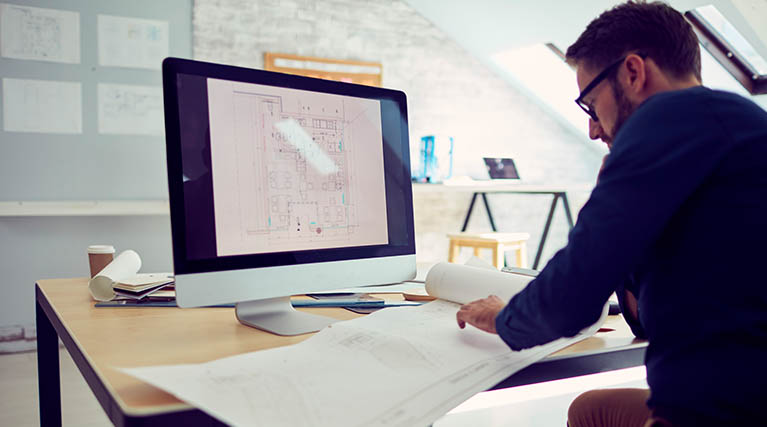 person drafting with AutoCAD® at desk.