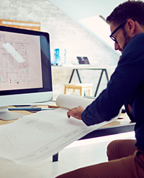 person drafting with AutoCAD® at desk.