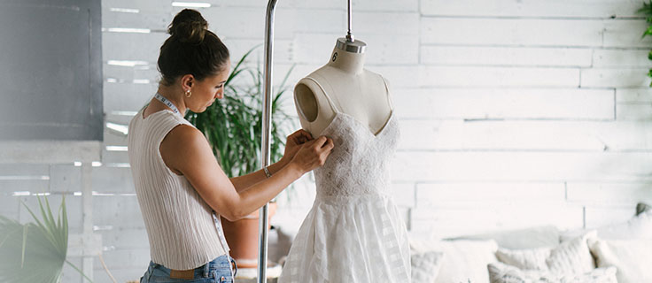 dressmaker altering a wedding dress.