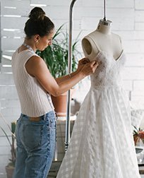 dressmaker altering a wedding dress.