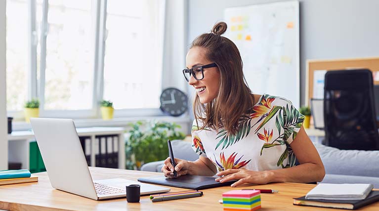 graphic designer using laptop and drawing tablet.