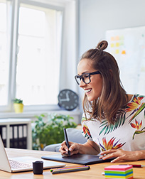 graphic designer using laptop and drawing tablet.