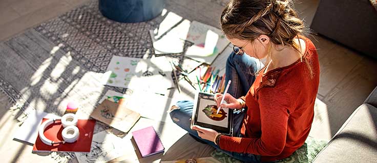 graphic designer illustrating image on tablet.